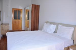 锡德Aquarius Hotel的卧室配有白色的床和木门