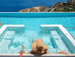 PalaiokastroMalvezzino Luxury Villas的戴帽子的女人在游泳池游泳