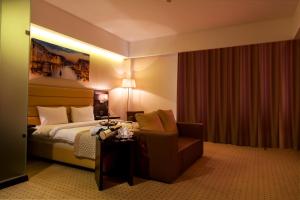 阿斯塔纳Comfort Hotel Astana的配有一张床和一把椅子的酒店客房