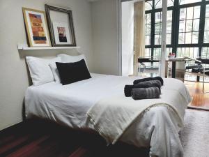 阿利坎特COLLECTION CITY - Bed & Breakfast, Alicante Center I Cocina & Amplia Terraza - Jardín的卧室配有一张带黑色枕头的大型白色床。