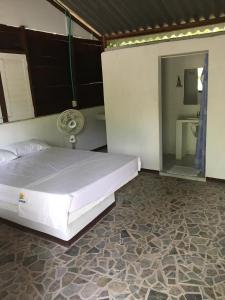 格兰德岛Eco Hotel Bosque Encantado的一间带白色床的卧室和一间浴室