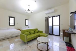 Dahan七星潭118海景民宿的客厅配有绿色沙发和床。