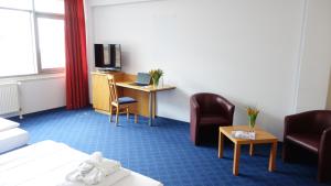 布伦瑞克Plaza Inn Braunschweig City Nord的酒店客房,配有一张床、一张桌子和椅子