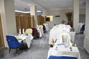 杜阿拉Hotel Royal Palace的一间设有白色桌椅的用餐室