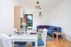 蒂瓦特Piskalina Apartment的客厅配有桌子和蓝色沙发