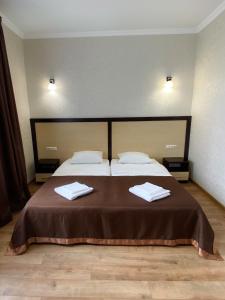 切尔诺夫策科拉尔酒店的一间卧室配有一张床,上面有两条毛巾