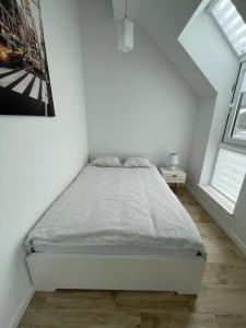 梅彻林基Biały Klif的一间白色卧室,配有床和2个窗户