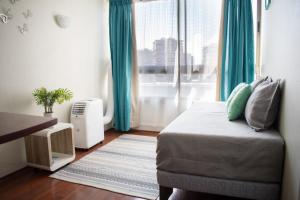 圣地亚哥Sweet Stay Chile的一间卧室配有一张带蓝色窗帘的床和一扇窗户