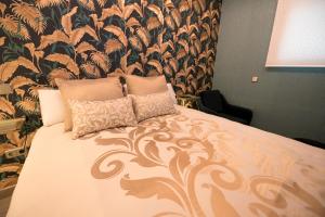 托雷洪-德阿尔多斯Hostal La Carretera的一间卧室配有一张带花卉壁纸的大床