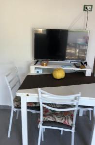 斯卡莱阿La Pedrosa 83的一张桌子、一台电视和一张桌子及两把椅子