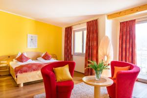 法克湖畔埃格Das Moser - Hotel Garni am See (Adults Only)的一间卧室配有一张床和两把椅子