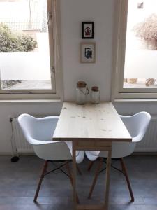 斯哈亨Tuinhuis的一个带两扇窗户的房间,配有一张桌子和两把椅子