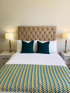 巴茅思Endeavour Guest House的一间卧室配有一张带蓝色枕头的大床