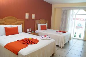 圣克鲁斯华特库Casa Danna Huatulco的酒店客房设有两张床和窗户。