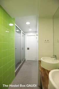 巴塞罗那格雷西亚火箭旅舍的一间带水槽、淋浴和镜子的浴室