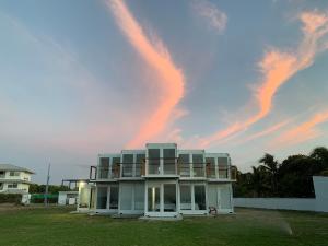 蓬塔查梅Nomada Republic Hotel Punta Chame的天空中带彩虹的白色房子