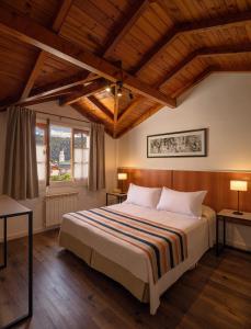 圣马丁德洛斯Hotel Intermonti的一间卧室设有一张带木制天花板的大床。