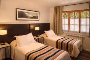 圣马丁德洛斯Hotel Intermonti的酒店客房设有两张床和窗户。
