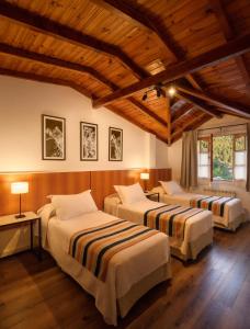 圣马丁德洛斯Hotel Intermonti的配有木天花板的客房设有两张床。