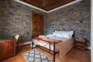 丰沙尔Ga281的一间卧室设有一张床和石墙