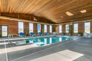WorlandComfort Inn Worland Hwy 16 to Yellowstone的大楼内带蓝色椅子的大型游泳池