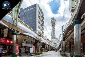 大阪@RLiS_house通天閣的一条城市街道,后面有塔楼