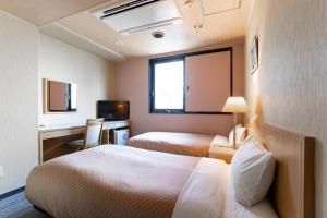 金泽金泽中央酒店 的酒店客房配有两张床和一张书桌