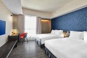 高雄高雄爱河智选假日酒店 的酒店客房设有两张床和电视。