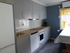 InnfjordenLensmansgarden Marteinsgarden的厨房配有白色橱柜和水槽