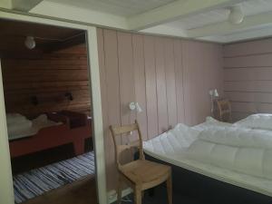 InnfjordenLensmansgarden Marteinsgarden的一间卧室配有一张床、一把椅子和镜子