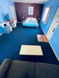 墨尔本东城汽车旅馆的客厅配有一张床和一张沙发