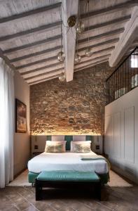 圣吉米纳诺Locanda dei Logi的一间卧室设有一张床和砖墙