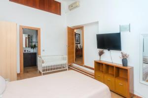 比尼贝卡Villa Abbas的一间卧室配有两张床和一台平面电视