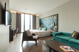 都灵DUPARC Contemporary Suites的酒店客房,配有床和沙发
