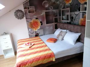 新瓦罗什Apartman Slavica的一间卧室配有一张带花墙的床