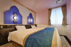 浦安Four Stories Hotel Maihama Tokyo Bay的一间卧室设有一张紫色墙壁的大床