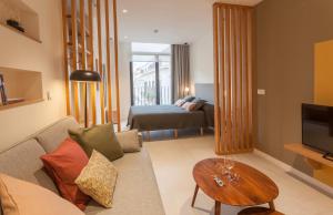 马拉加Apartamentos Málaga Premium - Calle Granada的客厅配有沙发、桌子和床。