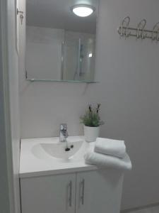 泰于Lilland Hostel Tau的白色的浴室设有水槽和镜子