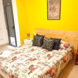 雷乌斯Apartamento en el centro的一间卧室设有一张黄色墙壁的大床