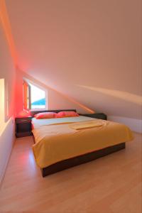 蒂瓦特Apartments Pean的一间卧室配有带橙色床单的床和窗户。
