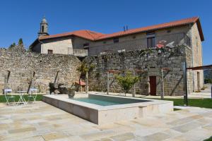 奥伦塞CASA RECTORAL DE SAN EUSEBIO的一座石头建筑,房子前面有一个游泳池