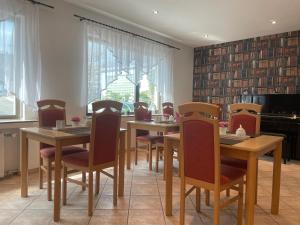 蒙海姆阳光酒店的用餐室配有木桌和椅子