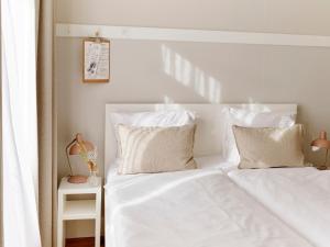 海滨诺德韦克佐纳尔酒店的白色的床、白色床单和枕头