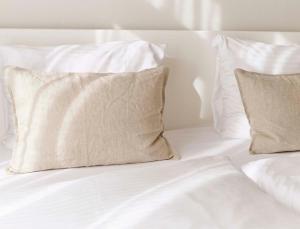海滨诺德韦克佐纳尔酒店的一张带白色床单和枕头的床