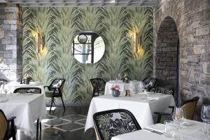 阿斯科纳卡斯特罗索尔海滩Spa度假村的一间设有白色桌子和壁画的餐厅