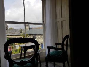 多尔盖罗Afallon Townhouse Gwynedd Room的窗前的两把椅子和一张桌子