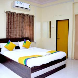 浦那Hotel Bestow Inn Koregaon Park Pune -Near Osho Ashram的一间卧室配有一张带色彩缤纷枕头的大床