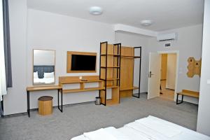 斯利文Hotel Ricas的一间卧室配有书桌、电脑和电视。