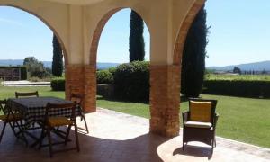 圣吉米纳诺Agriturismo Fattoria il Piano - Casa Bugno - San Gimignano的大楼内带桌椅的天井