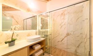罗希姆诺Pal Calma Suites的一间带玻璃淋浴和水槽的浴室
